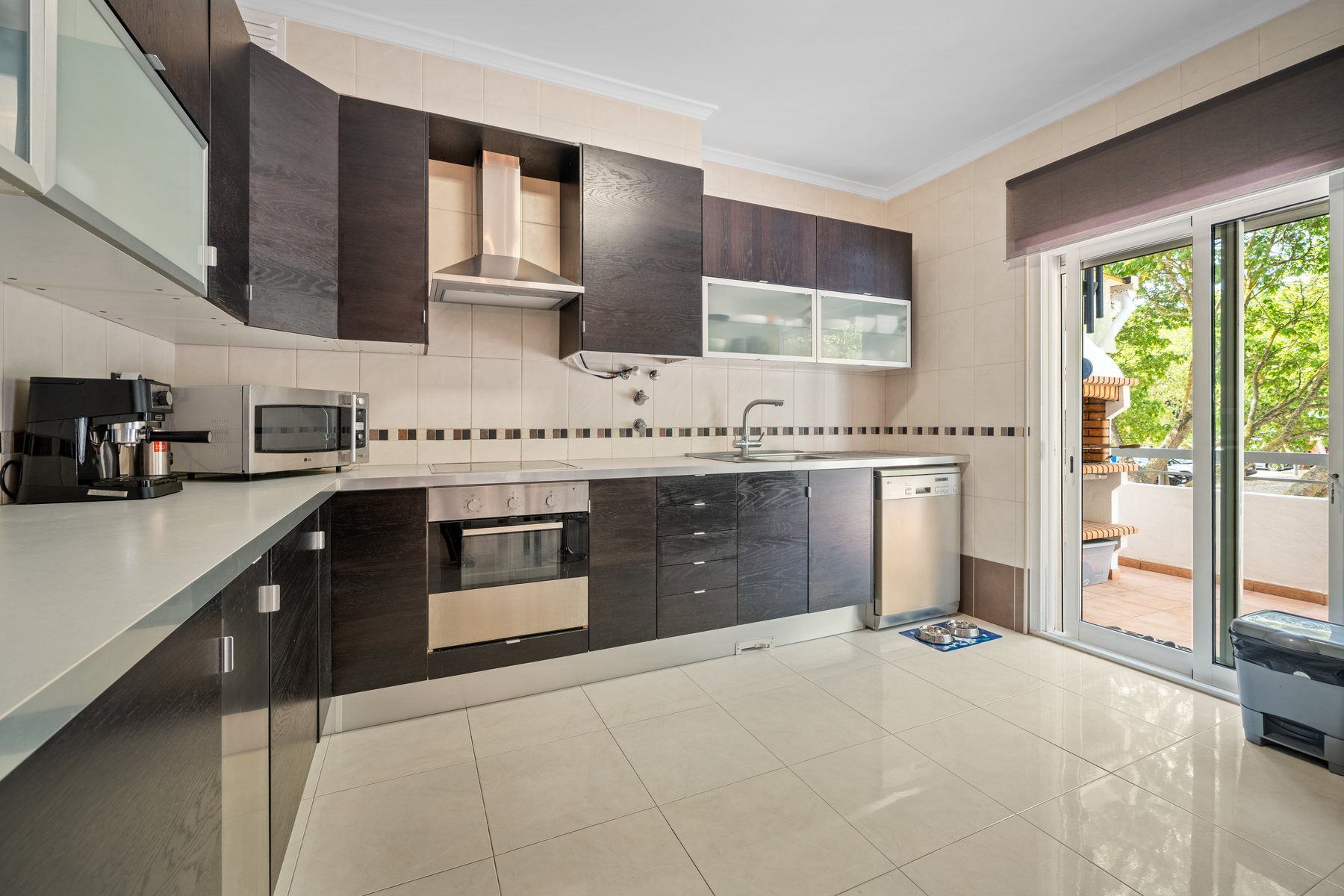 Tavira townhouse — fitted kitchen with dark cabinetry opening to the terrace